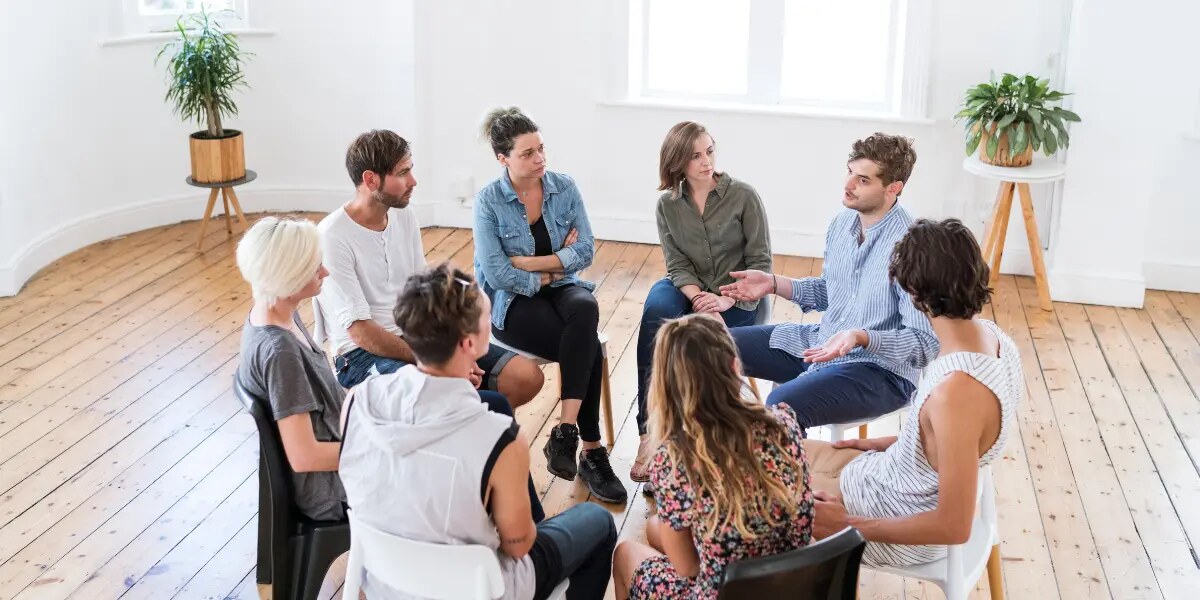 Personas adultas conversan en un encuentro grupal.